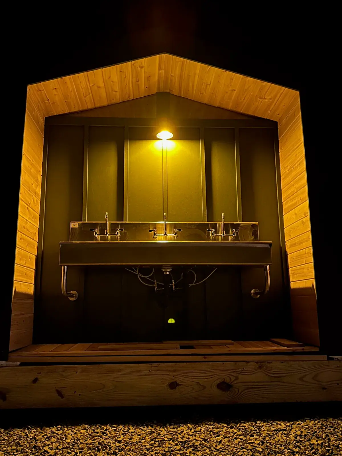 Lit interior of a Pine bathhouse with a trough sink