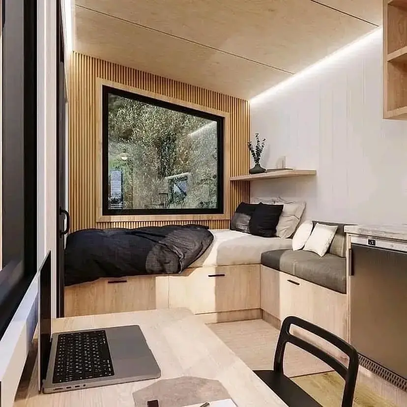 Cabin interior with a bed nook, seating, and a workspace